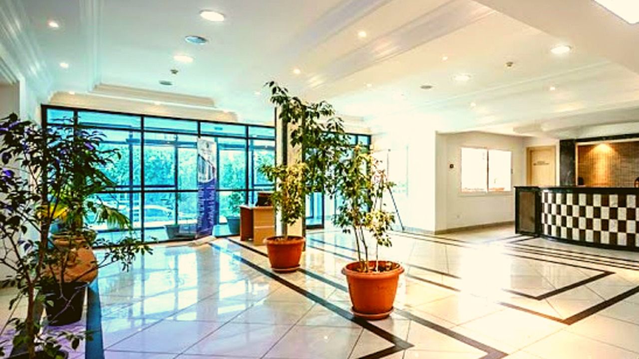Hall d'accueil clair de la clinique, plantes et comptoir.
